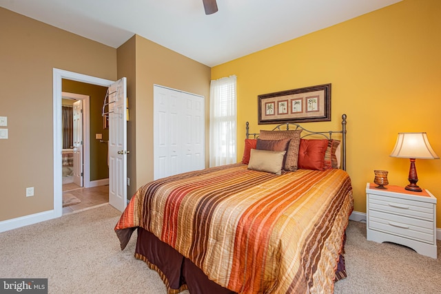 bedroom featuring carpet floors, a closet, ceiling fan, ensuite bathroom, and baseboards