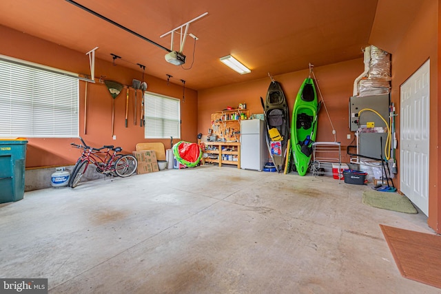 garage with freestanding refrigerator and a garage door opener