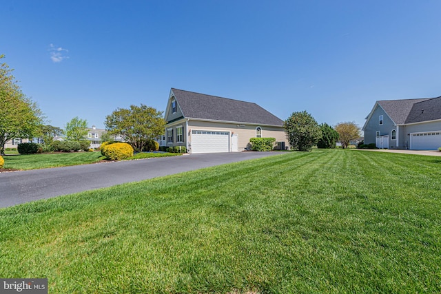 view of side of home with a lawn and aphalt driveway