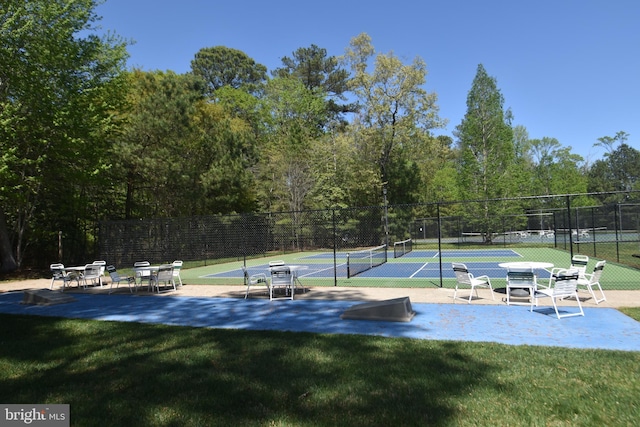 view of home's community with a tennis court, fence, and a lawn