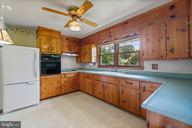 kitchen with black appliances, light countertops, a ceiling fan, a sink, and brown cabinetry