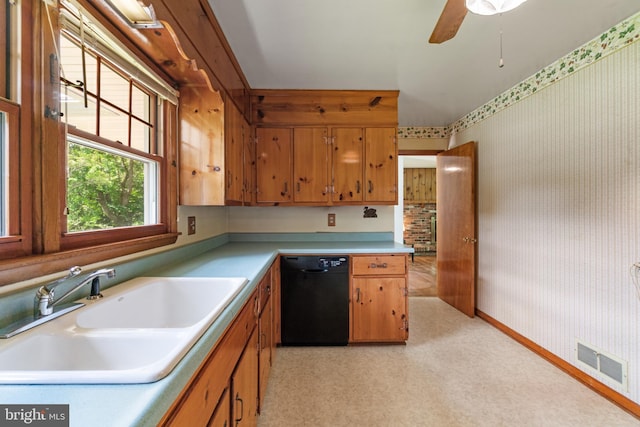 kitchen with black dishwasher, a sink, wallpapered walls, light countertops, and brown cabinetry