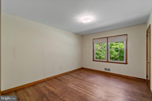 spare room featuring wood finished floors and baseboards