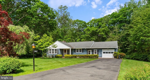view of front of property with a garage, asphalt driveway, and a front yard