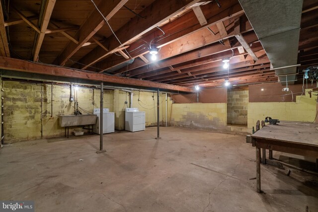 unfinished below grade area featuring washing machine and dryer and a sink