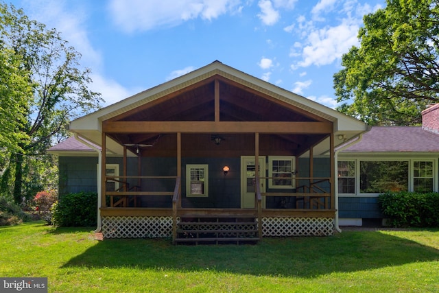 back of property featuring a sunroom, a lawn, and a chimney