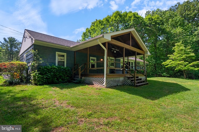 back of property with a yard and a shingled roof