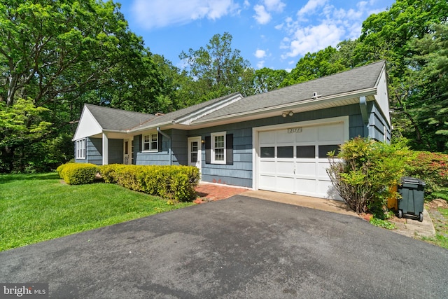 ranch-style home featuring a garage, asphalt driveway, a front lawn, and a shingled roof