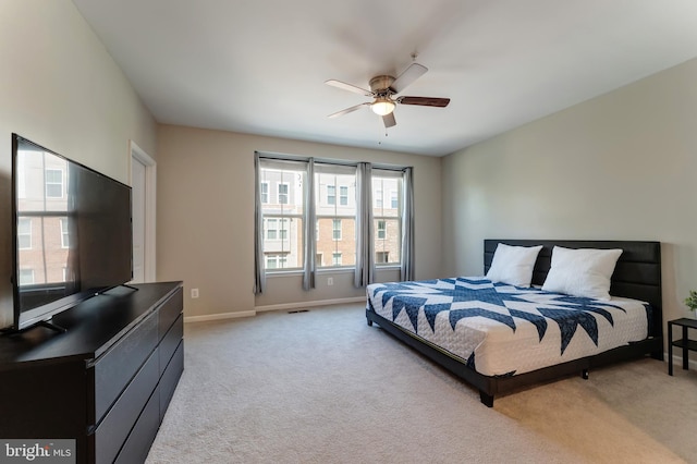 bedroom with a ceiling fan, baseboards, light colored carpet, and visible vents