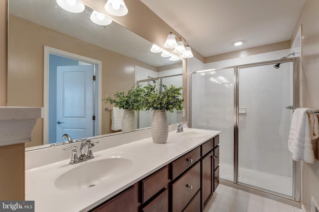 bathroom featuring double vanity, tile patterned floors, a sink, and a stall shower