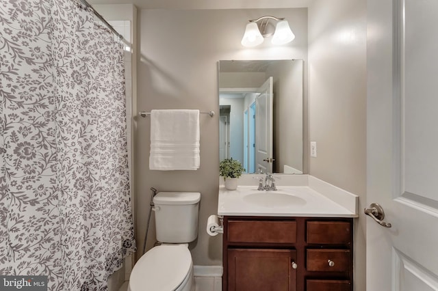 bathroom with vanity, curtained shower, and toilet