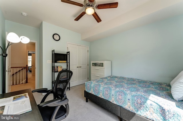bedroom featuring ceiling fan, light carpet, and a closet