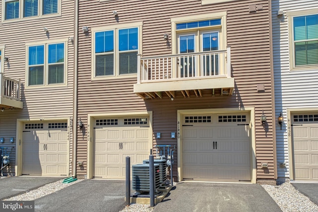garage with driveway and cooling unit