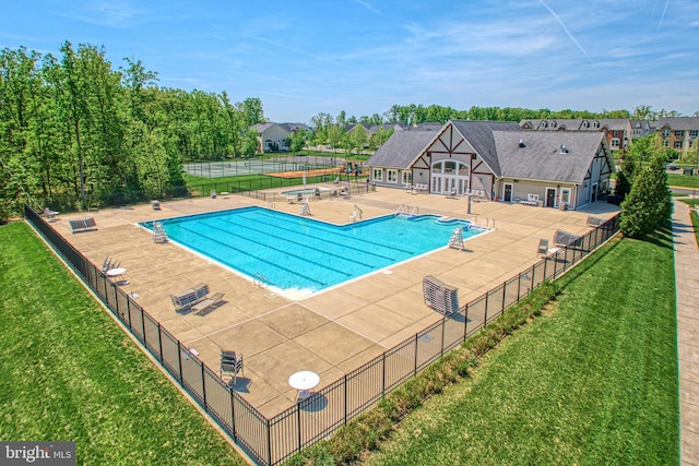 community pool featuring a yard, fence, and a patio area