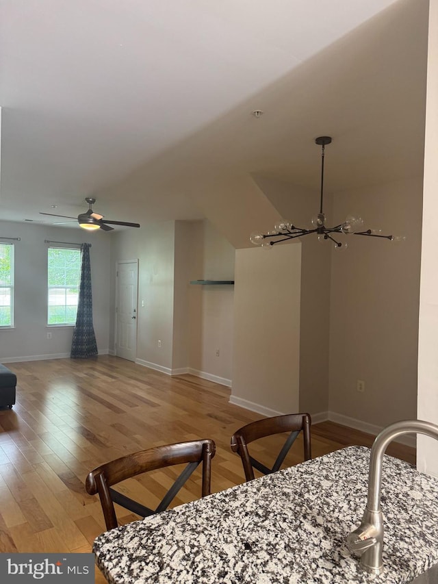 42429 Rockrose Sq, Brambleton, VA 20148 - dining area with light wood-type flooring, a chandelier, baseboards, and ceiling fan