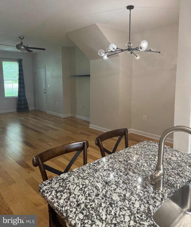 42429 Rockrose Sq, Brambleton, VA 20148 - dining room with light wood-style floors, baseboards, a ceiling fan, and a chandelier