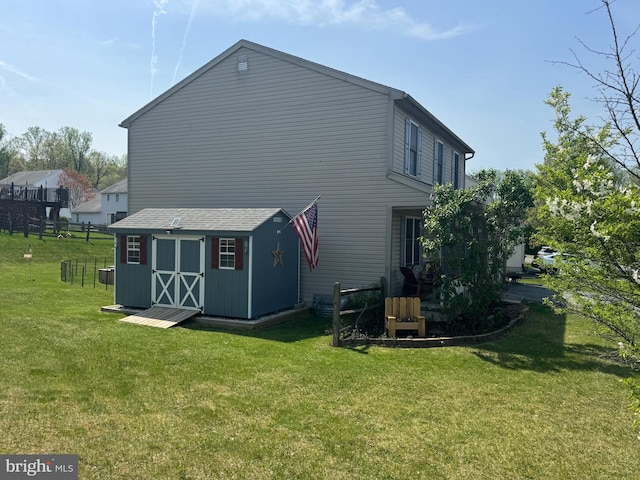 back of property featuring a storage unit, an outbuilding, and a yard