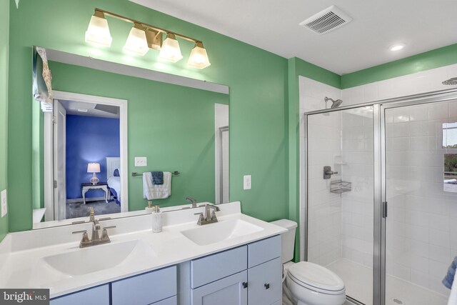 ensuite bathroom with visible vents, a sink, and a stall shower