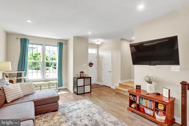 living area featuring baseboards, plenty of natural light, recessed lighting, and wood finished floors