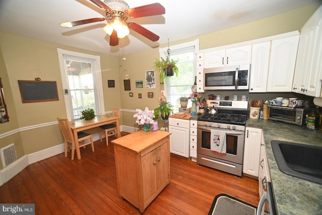 kitchen with white cabinets, appliances with stainless steel finishes, butcher block countertops, wood finished floors, and visible vents