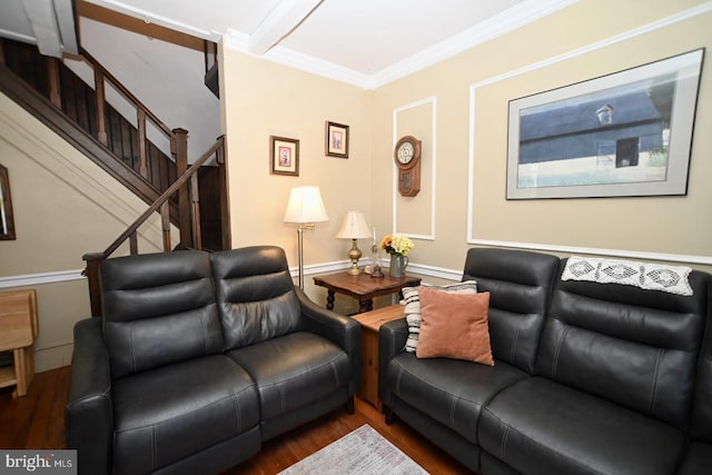 living area with baseboards, ornamental molding, wood finished floors, and stairway