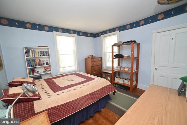 bedroom with baseboards and wood finished floors
