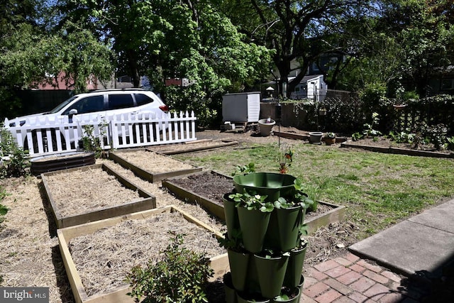 view of yard featuring fence and a vegetable garden