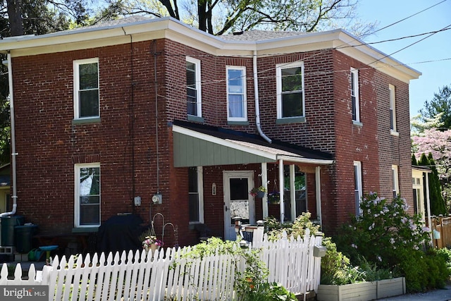 view of front of property featuring brick siding and fence