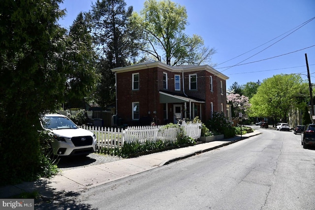 view of front of house featuring brick siding and fence private yard
