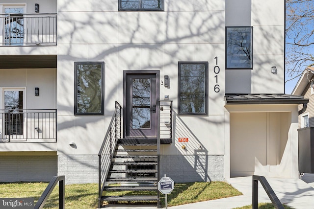 1016 Rhode Island Ave NE Unit 1, Washington, DC 20018 - view of exterior entry featuring stucco siding, a standing seam roof, and a balcony