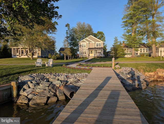 dock area with a residential view and a lawn