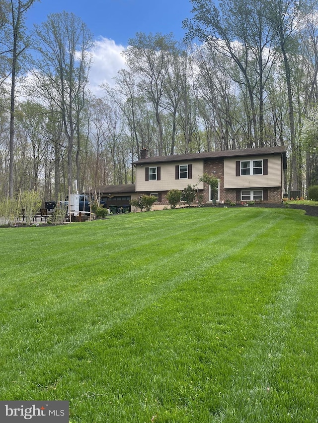 8807 Doug Dr, Nokesville, VA 20181 - bi-level home featuring brick siding, a front lawn, and a chimney