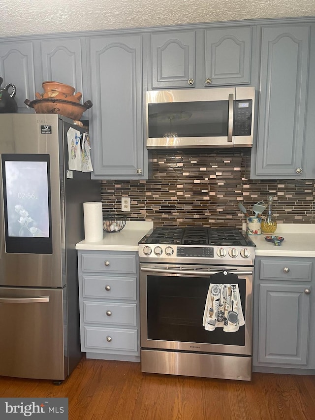8807 Doug Dr, Nokesville, VA 20181 - kitchen featuring backsplash, gray cabinetry, appliances with stainless steel finishes, and light countertops