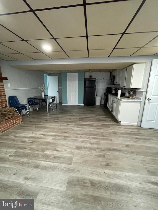 8807 Doug Dr, Nokesville, VA 20181 - interior space featuring a paneled ceiling, light wood finished floors, black appliances, and white cabinets