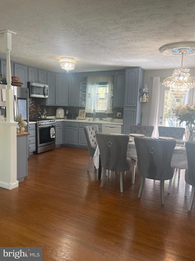 8807 Doug Dr, Nokesville, VA 20181 - dining space featuring dark wood-style flooring, a textured ceiling, and a chandelier
