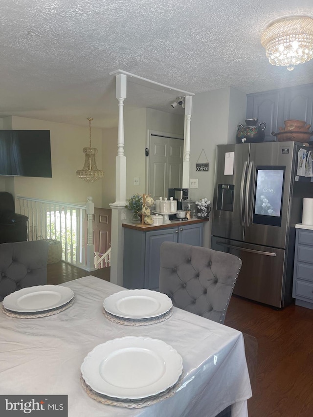 8807 Doug Dr, Nokesville, VA 20181 - dining space featuring dark wood-type flooring, a textured ceiling, and a chandelier