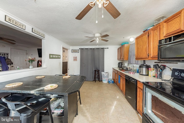 kitchen with brown cabinetry, a sink, black dishwasher, electric range oven, and a ceiling fan