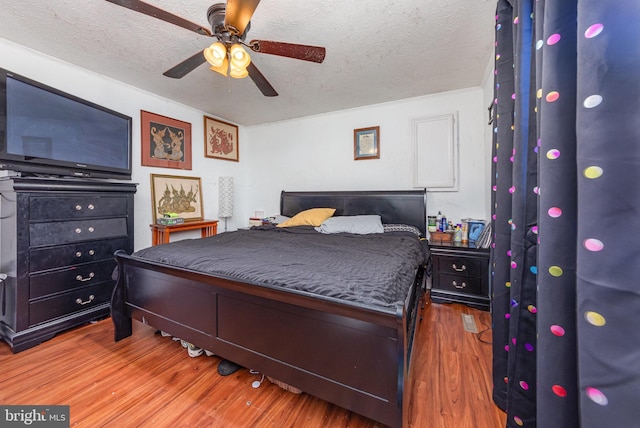 bedroom featuring a ceiling fan, a textured ceiling, and wood finished floors