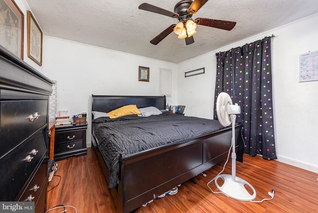 bedroom with baseboards, a textured ceiling, ceiling fan, and wood finished floors
