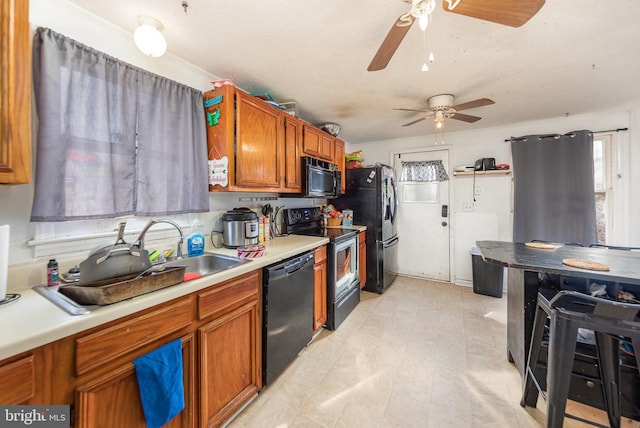 kitchen featuring a sink, a ceiling fan, black appliances, and brown cabinets