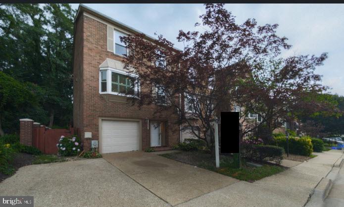 10941 Pebble Run Dr, Silver Spring, MD 20902 - view of front of property with brick siding, an attached garage, and concrete driveway