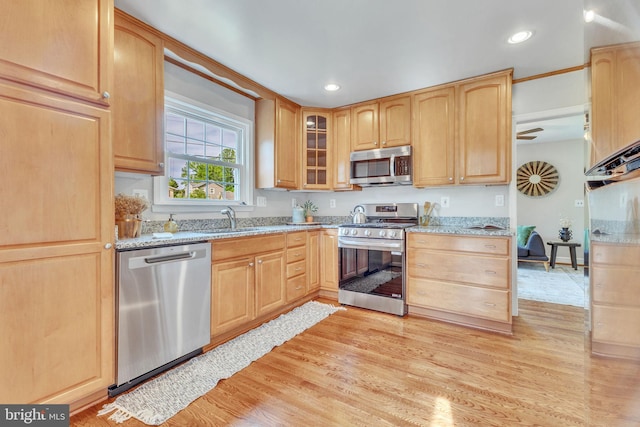 kitchen with appliances with stainless steel finishes, light stone counters, light brown cabinetry, and recessed lighting