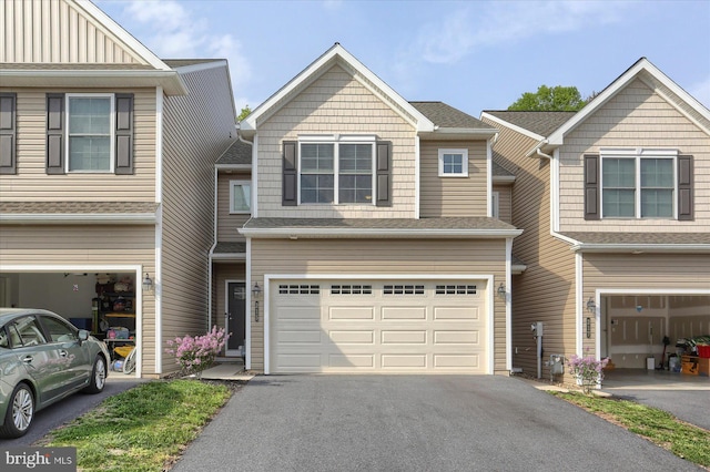 multi unit property featuring an attached garage and aphalt driveway