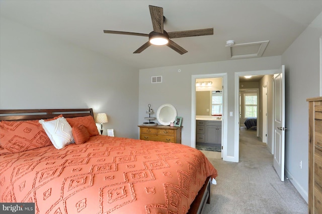 bedroom featuring attic access, visible vents, light colored carpet, baseboards, and connected bathroom