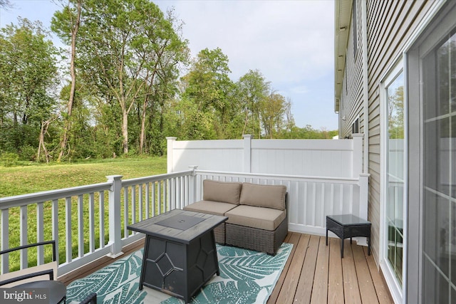 wooden terrace featuring an outdoor living space and a lawn