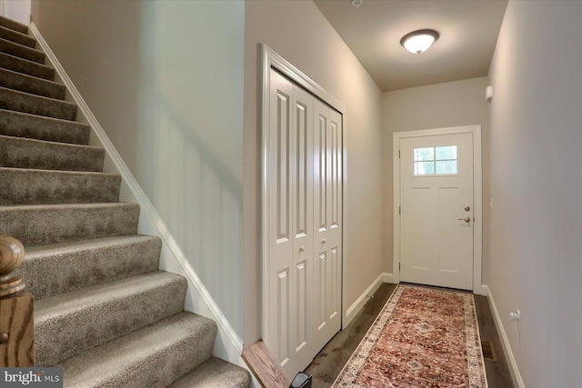 doorway to outside with baseboards, wood finished floors, and stairway