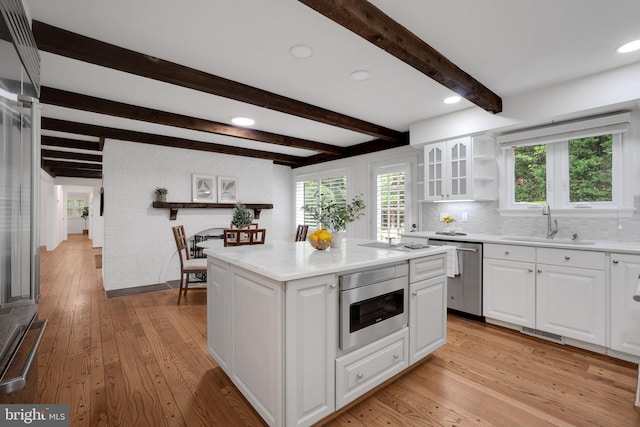2407 Mare Ln, Oakton, VA 22124 - kitchen featuring appliances with stainless steel finishes, a sink, light wood-type flooring, white cabinets, and beam ceiling