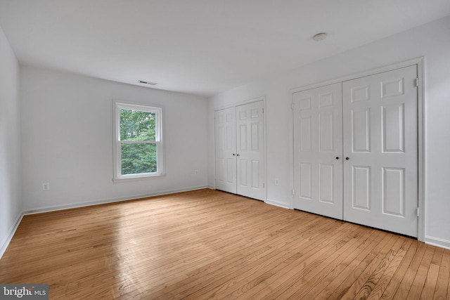 2407 Mare Ln, Oakton, VA 22124 - unfurnished bedroom with two closets, hardwood / wood-style floors, and baseboards