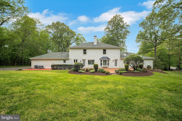 2407 Mare Ln, Oakton, VA 22124 - rear view of property with a chimney, a yard, and central AC