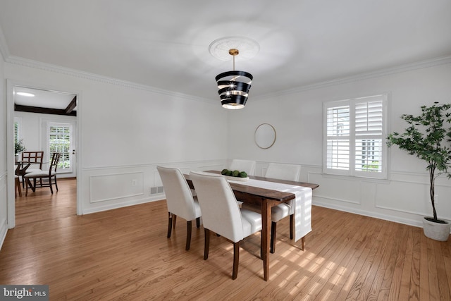 2407 Mare Ln, Oakton, VA 22124 - dining area with crown molding, light wood finished floors, a decorative wall, wainscoting, and a chandelier